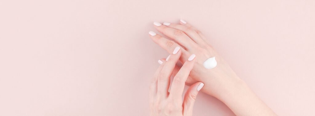 cropped-hands-woman-with-moisturizer-pink-background (1)